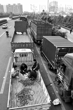 四川成為此次油荒的重災(zāi)區(qū)。圖為排隊等候加油的貨車司機以打牌來打發(fā)時間。