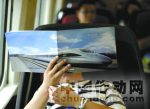 運行的高鐵列車上，一名記者在看材料。