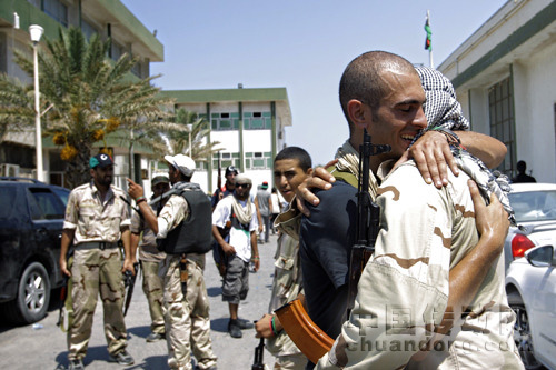 22日，利比亞首都的黎波里，兩名反對派武裝人員擁抱在一起。